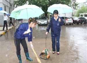 陝西澄合煤化實業王村社區環衛職工冒雨衝刷路麵